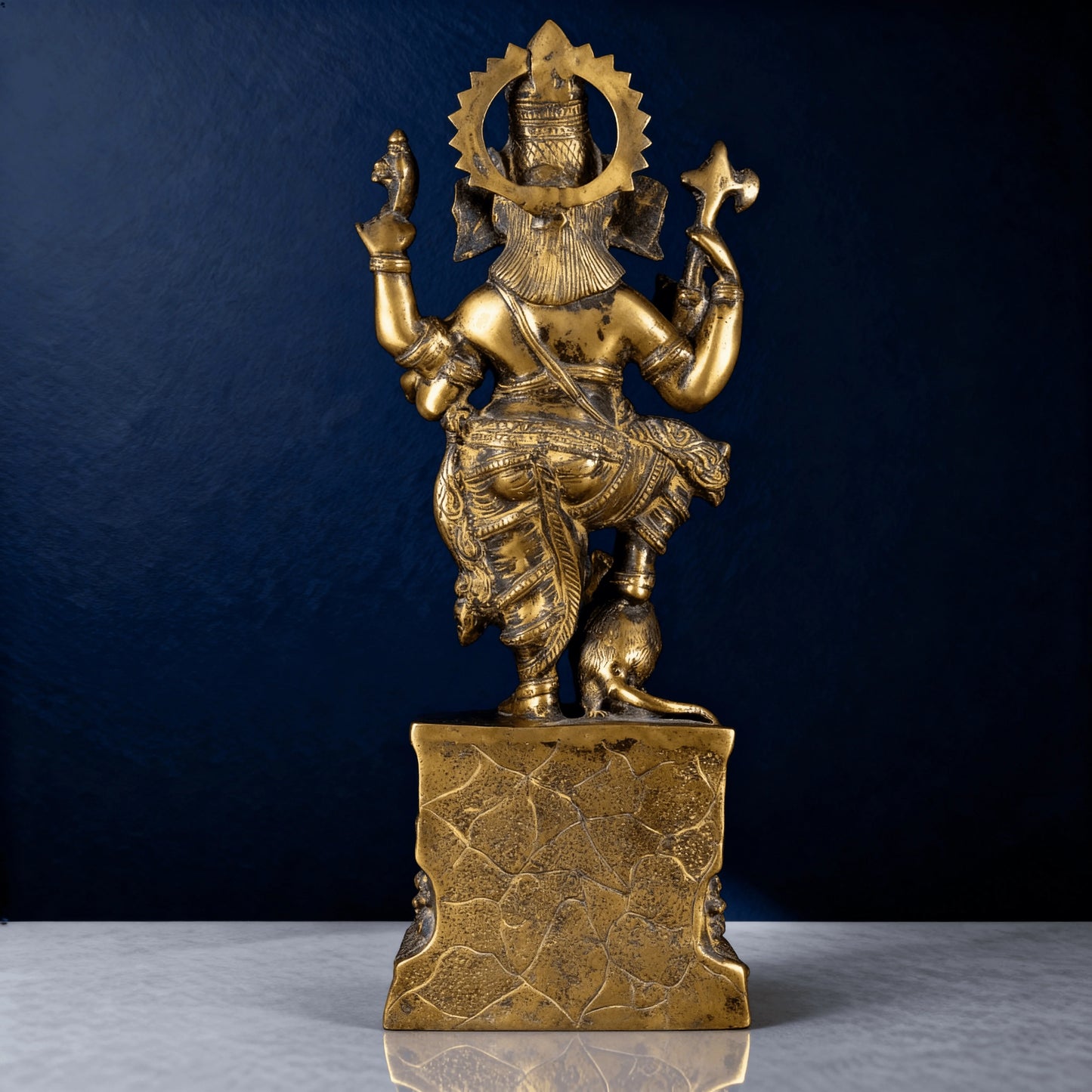 Back view of antique brass dancing Ganesha statue showing detailed craftsmanship and carved halo design