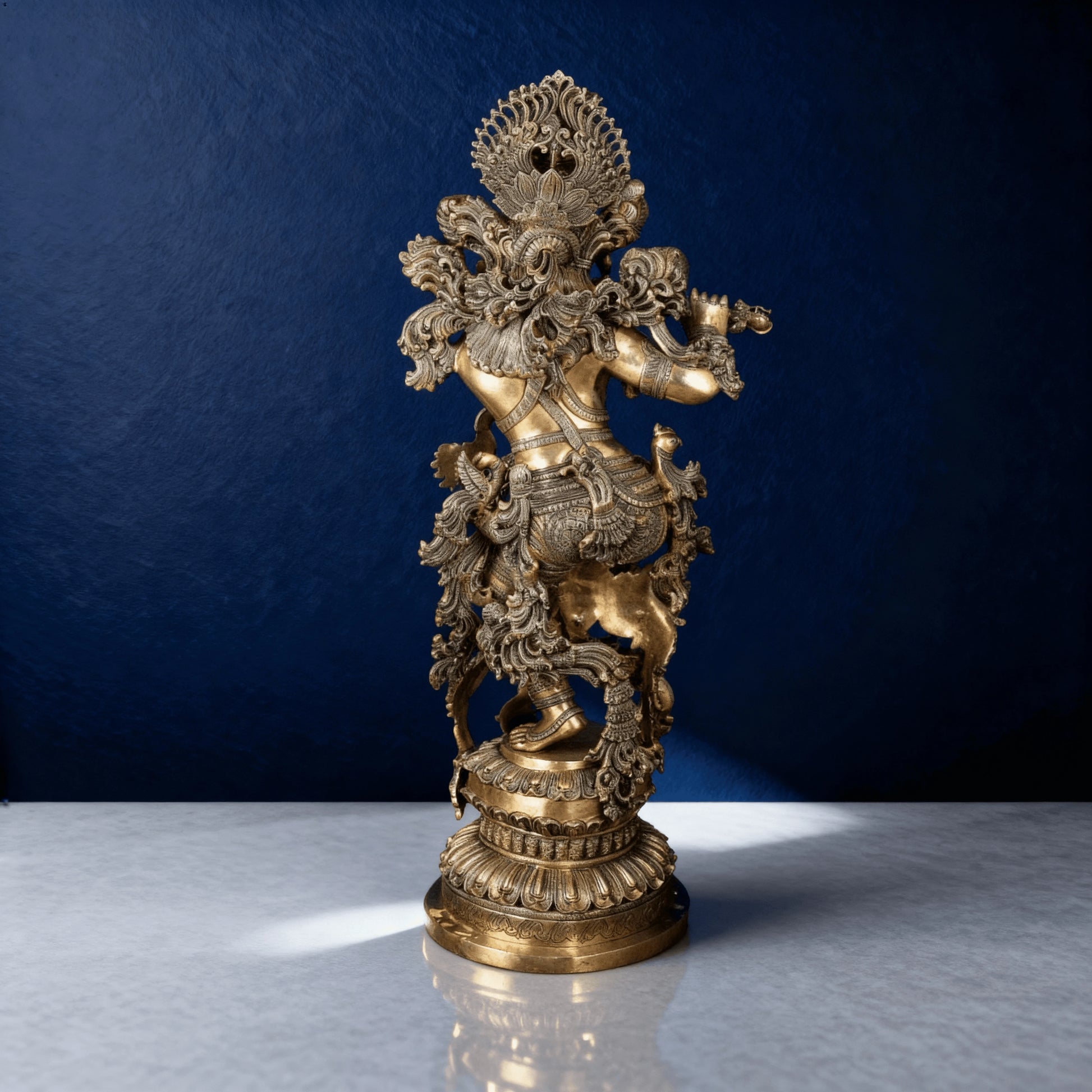 Brass Lord Krishna statue with intricate carvings playing flute on ornate pedestal