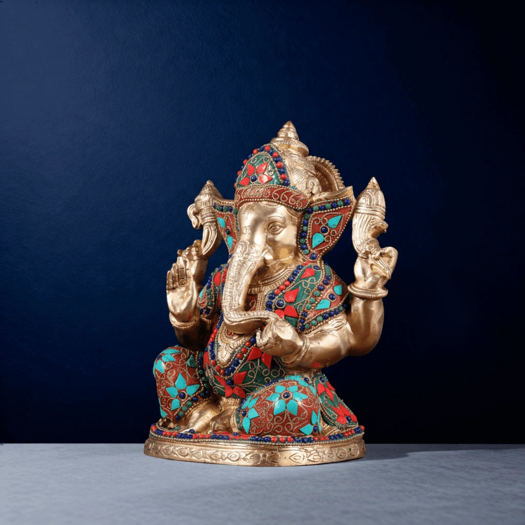 Side view of turquoise and red stonework brass Ganesha idol on studio background