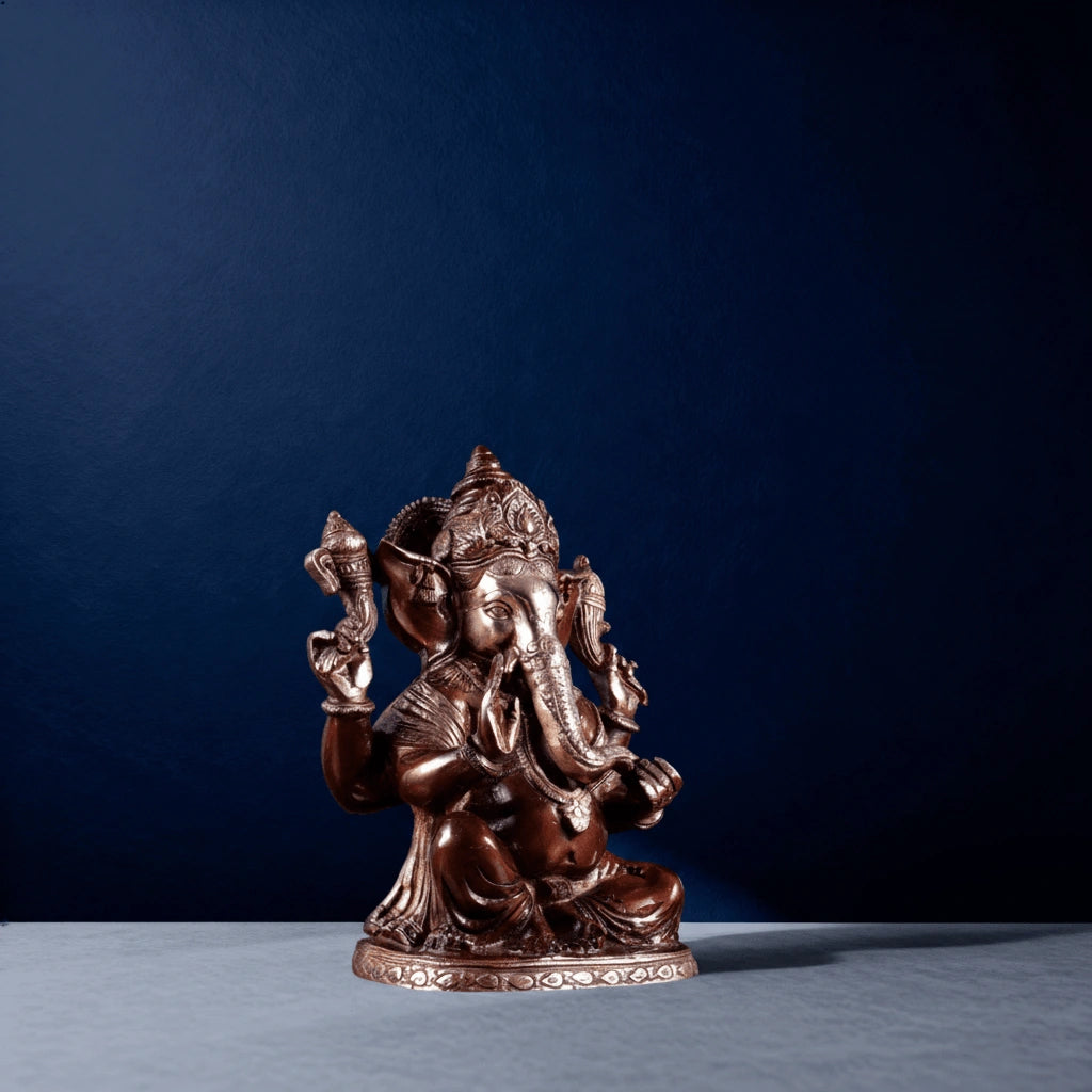 Side-angle shot of antique brass Ganesha idol showing ornate carvings and traditional Indian craftsmanship