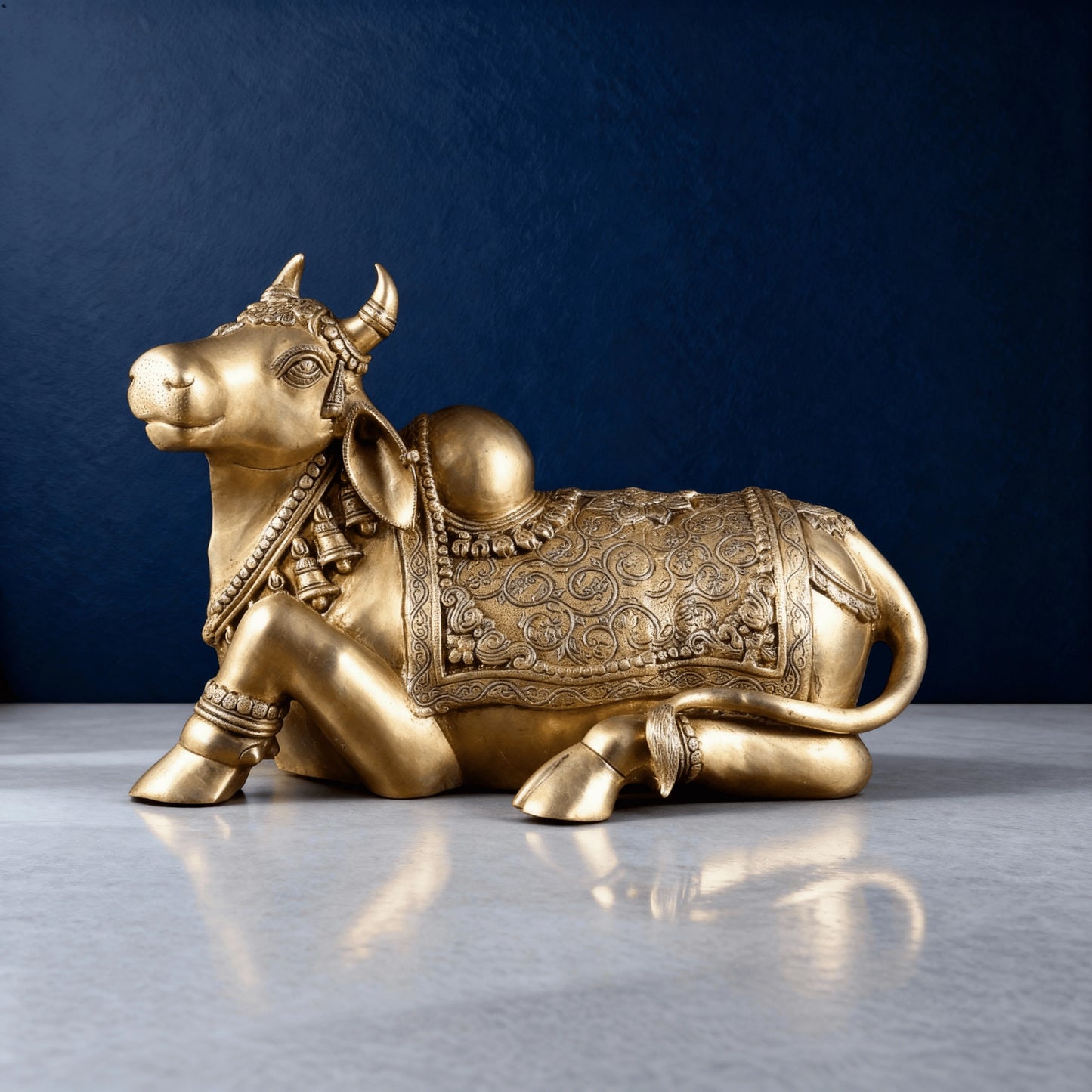 studio shot of handcrafted brass Nandi sculpture with intricate neck jewelry and patterned saddle detailing