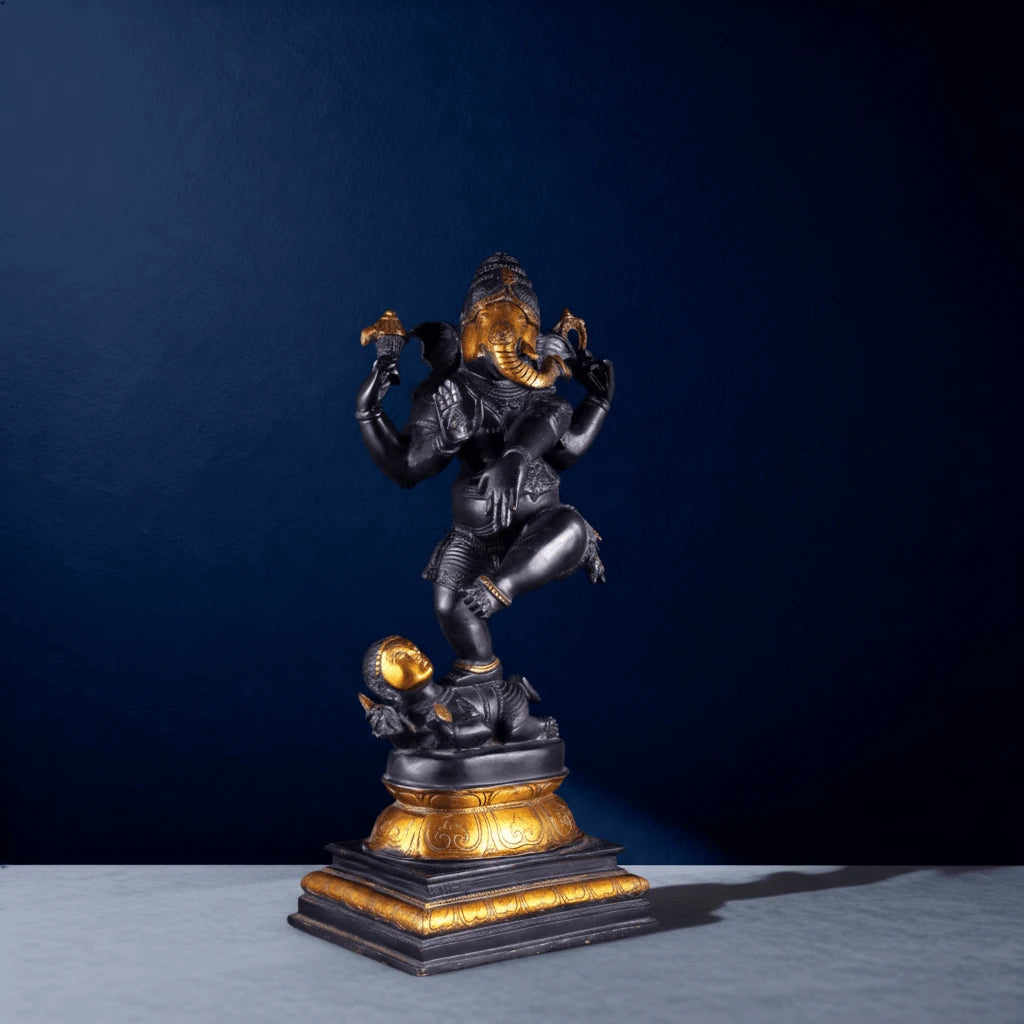 Angled front-left view of elegant black Ganesha statue with golden highlights and raised leg posture