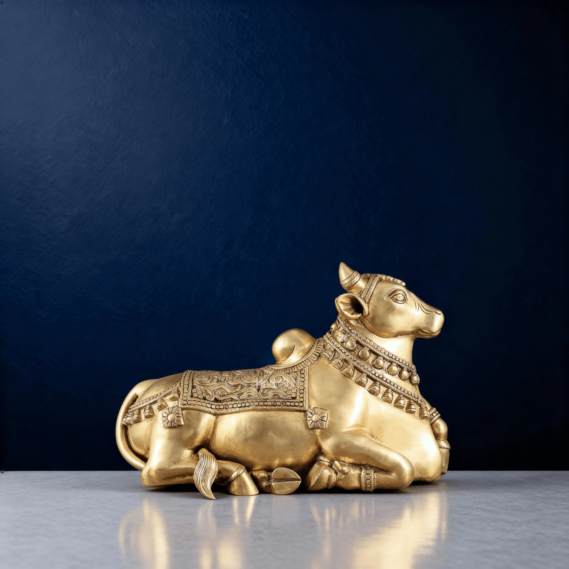 Side profile of brass Nandi idol showing carved necklace and saddle design