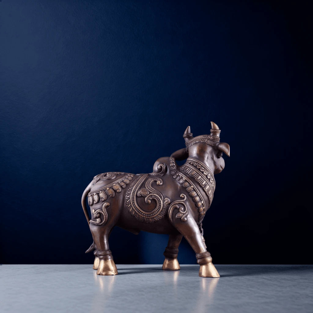 brass standing nandi statue with intricate carvings on a marble surface