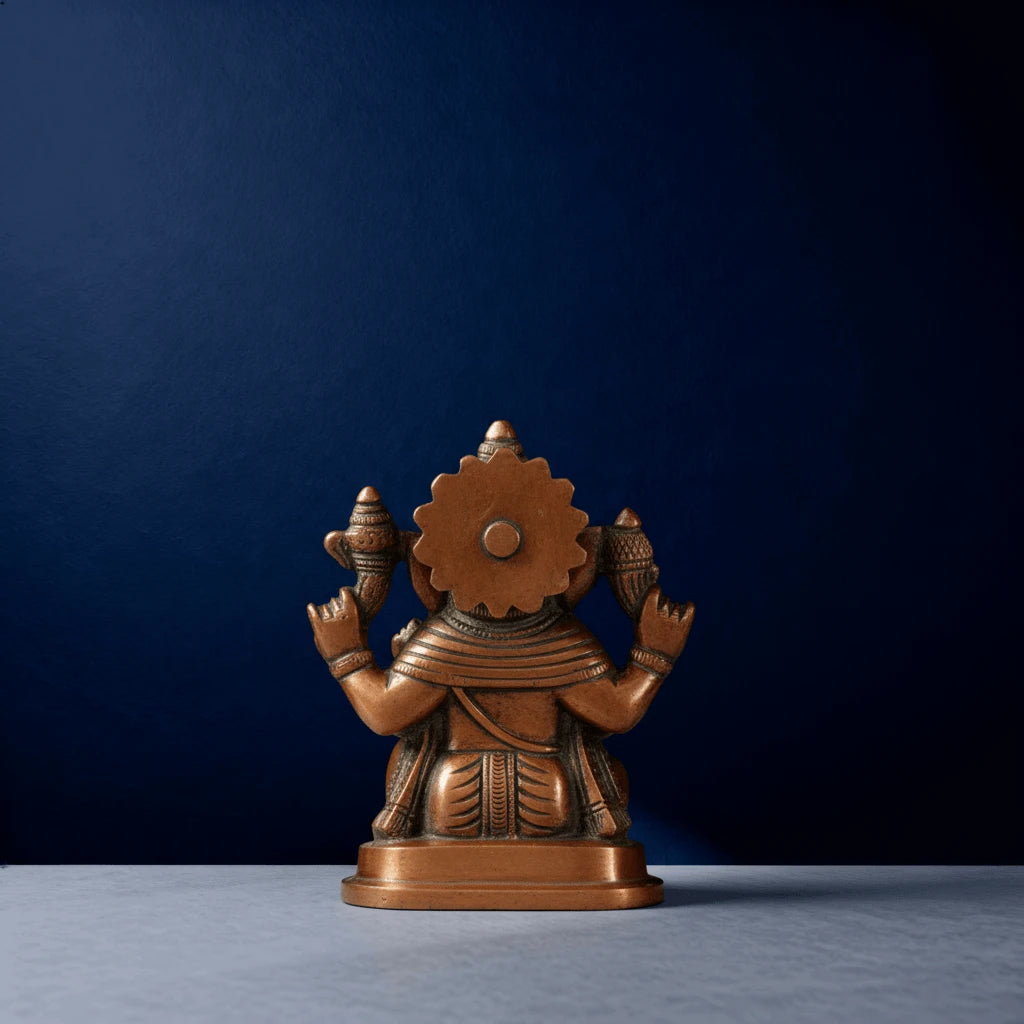 Rear view of traditional brass Ganesha statue showcasing detailed craftsmanship and textured robe design