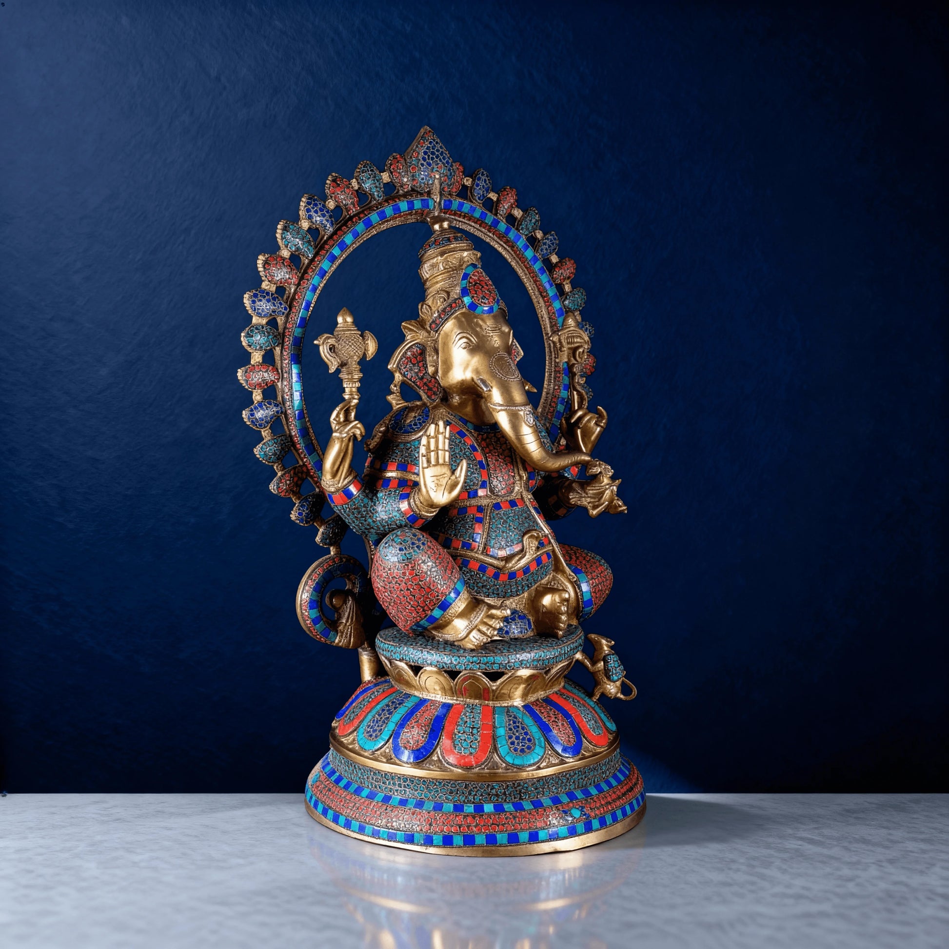 Side-angle view of handcrafted meenakari brass Ganesha idol with intricate detailing and vibrant stone inlay work