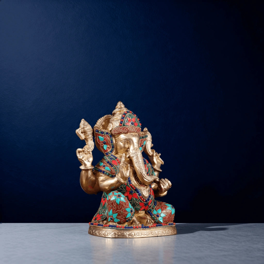 Multicolor stone-studded brass Ganesha statue side angle on blue background