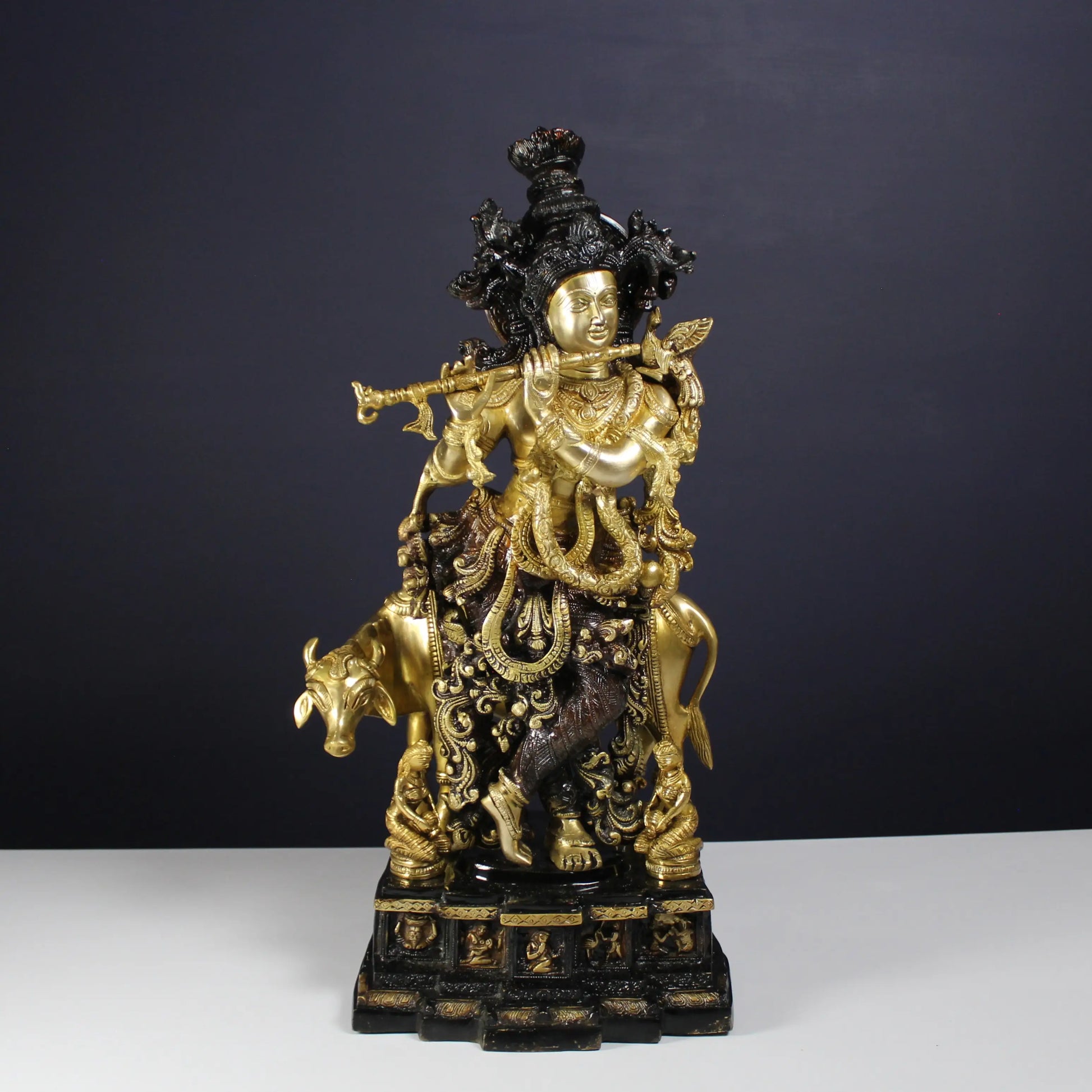 Decorative Krishna statue of a figure on a bull with intricate details against a dark background