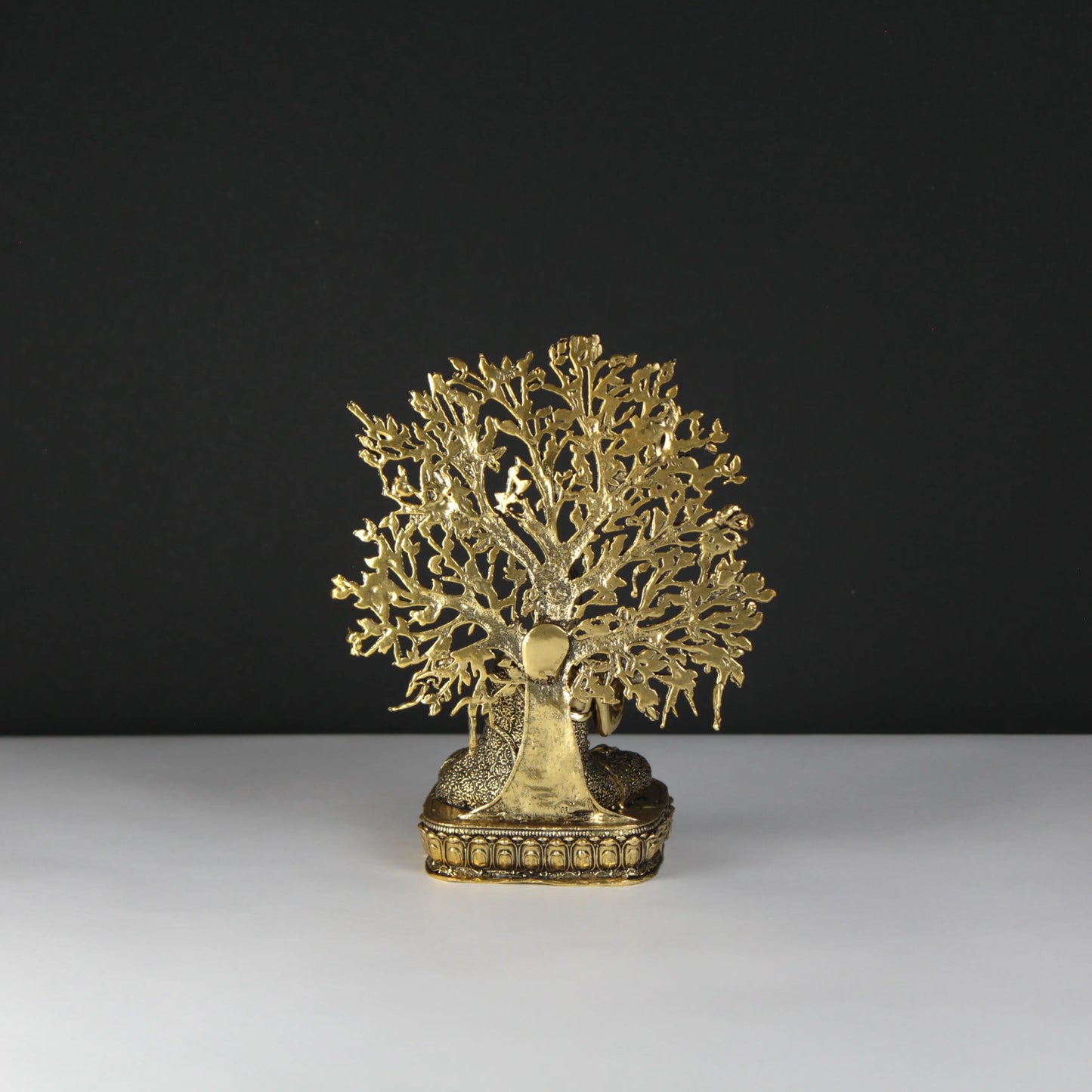 Gold tree-shaped decorative object on a black and white background