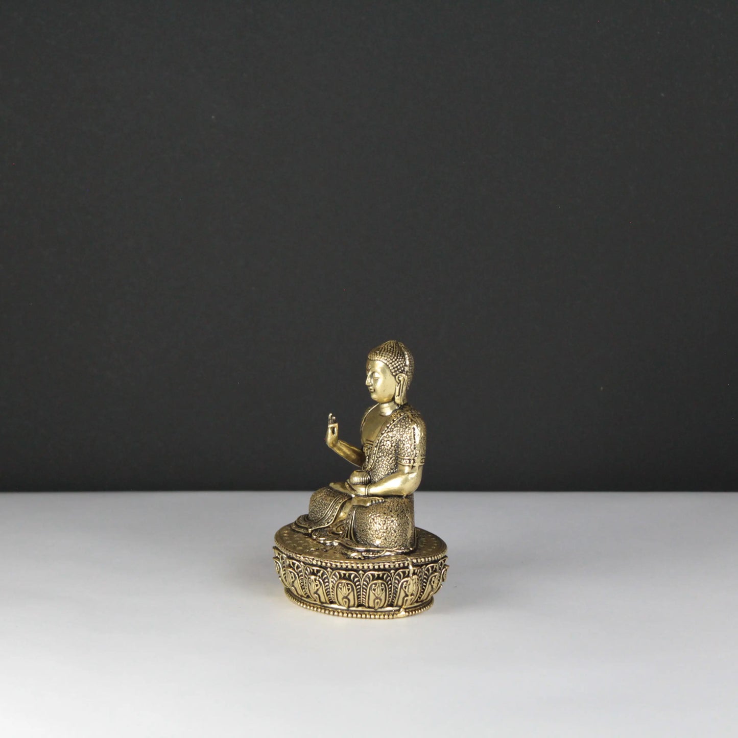 Gold Buddha statue on a dark gray background