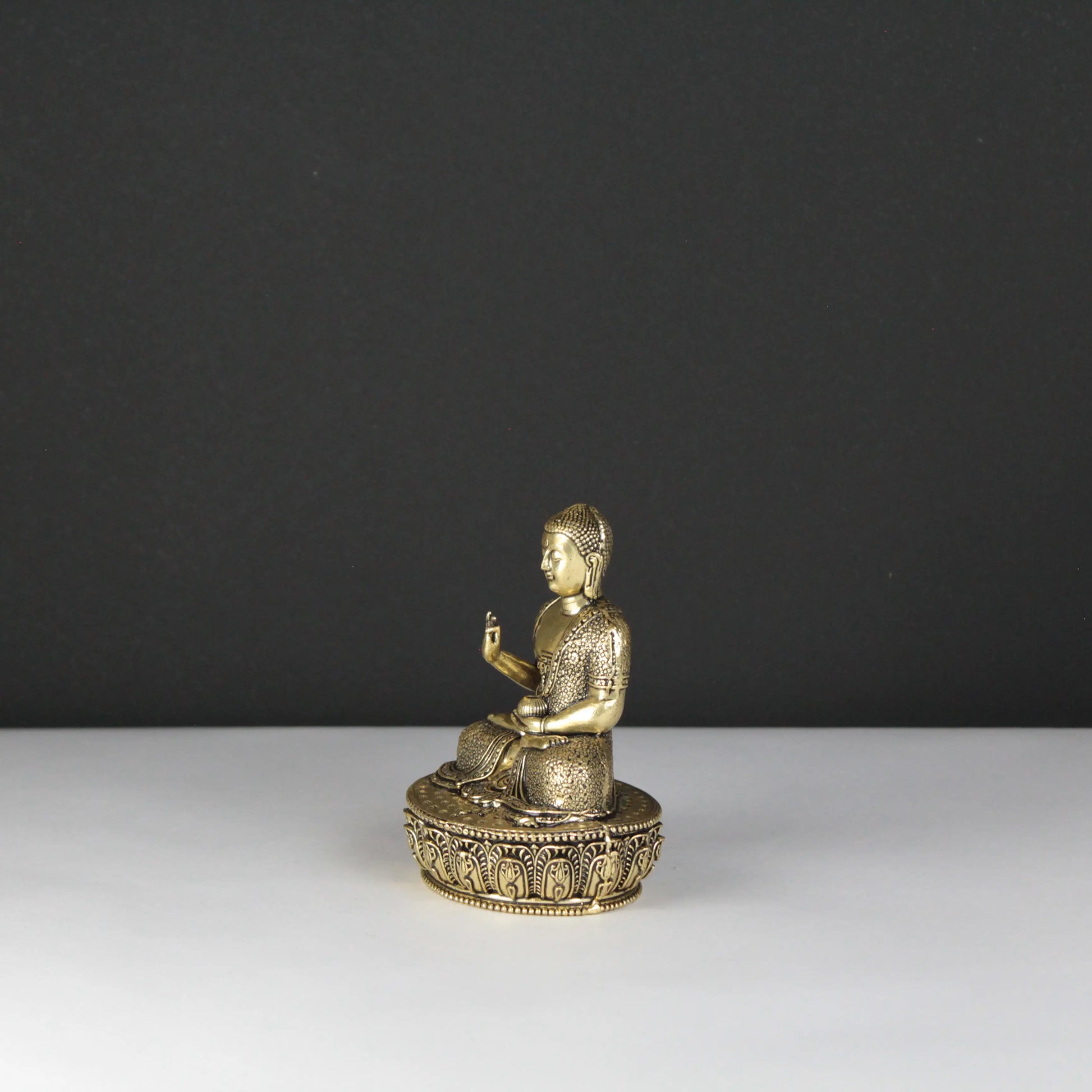 Gold Buddha statue on a dark gray background