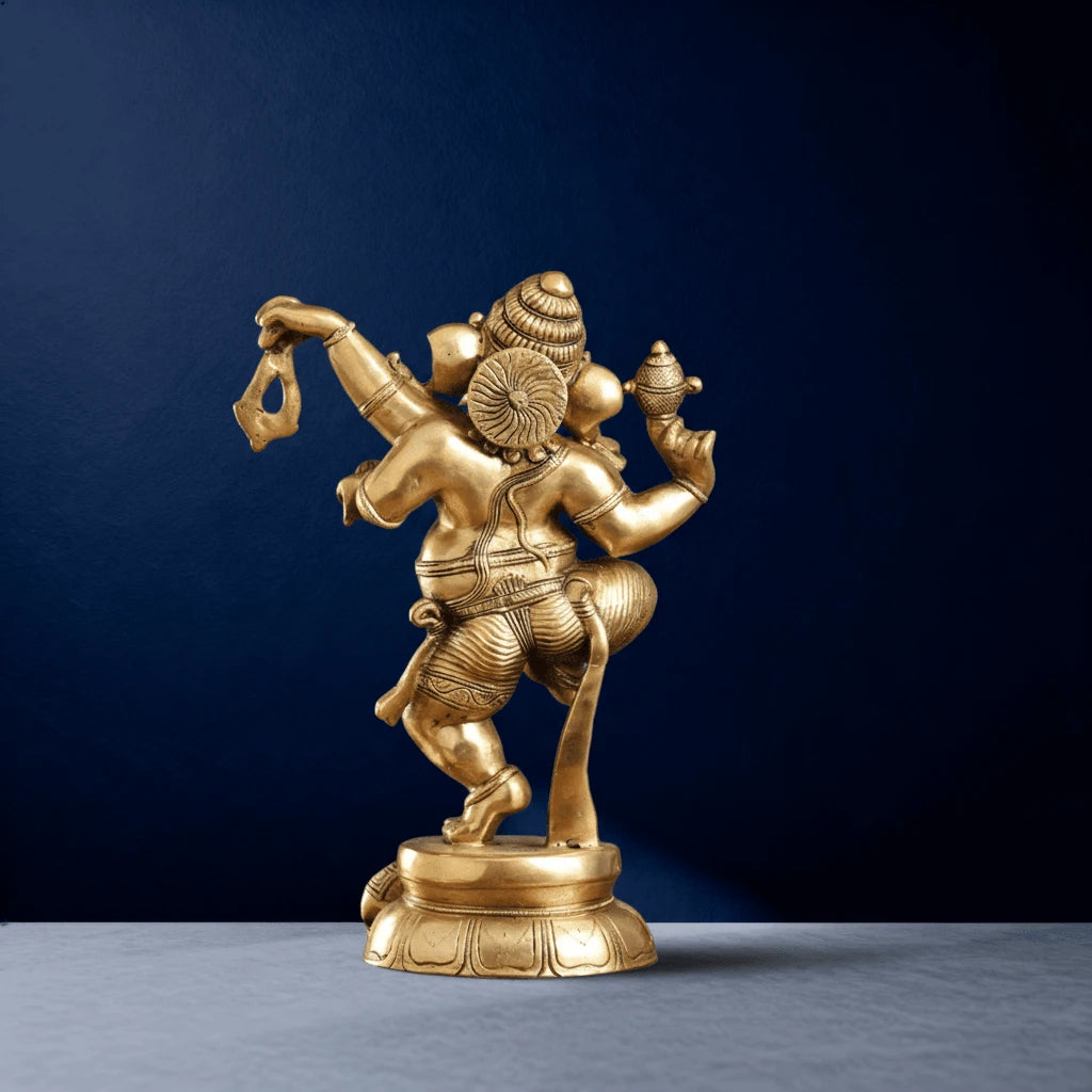 Back view of golden Ganapati sculpture showing intricate headgear and dhoti carvings