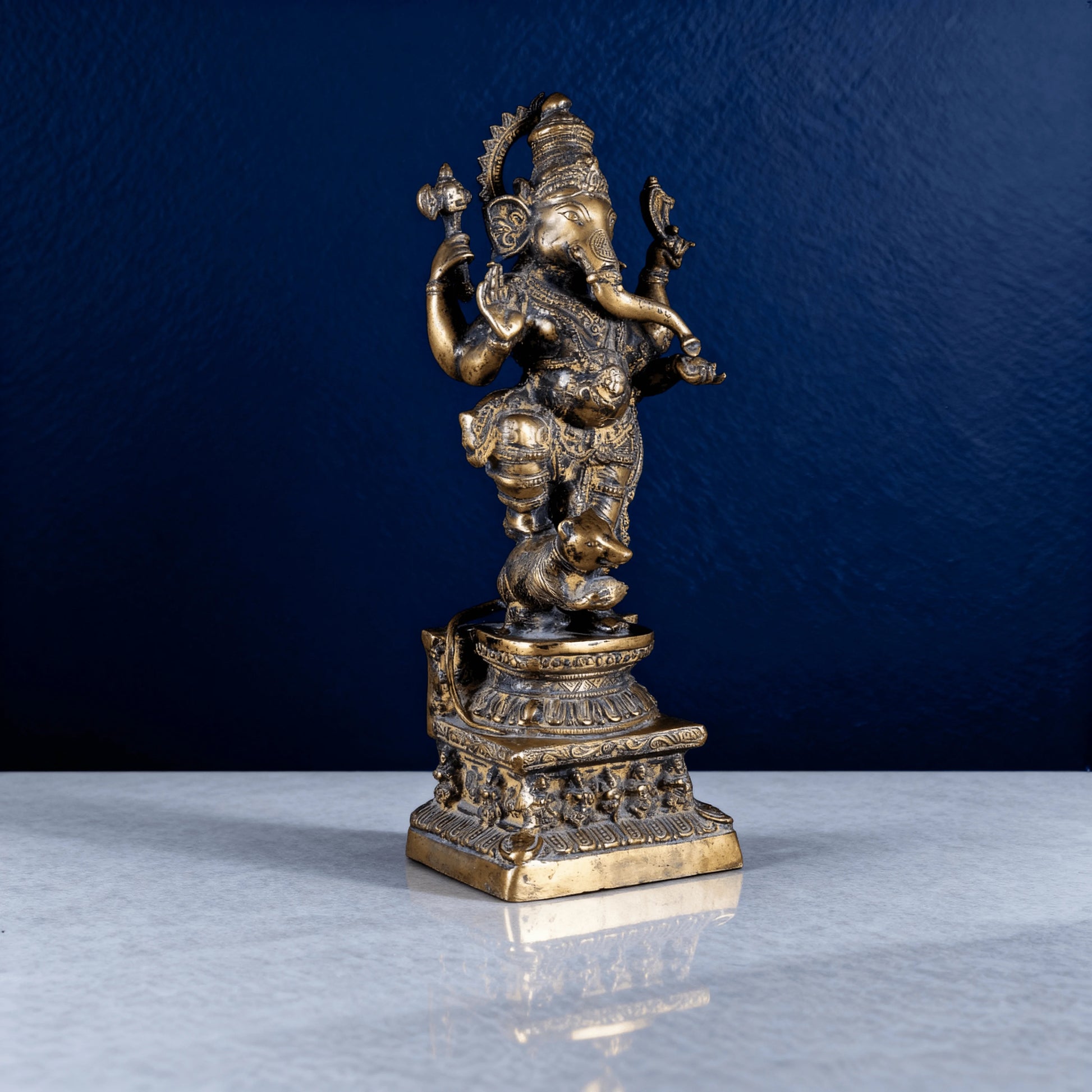 Side-angle view of handcrafted brass dancing Ganesha statue with ornate details and decorative base