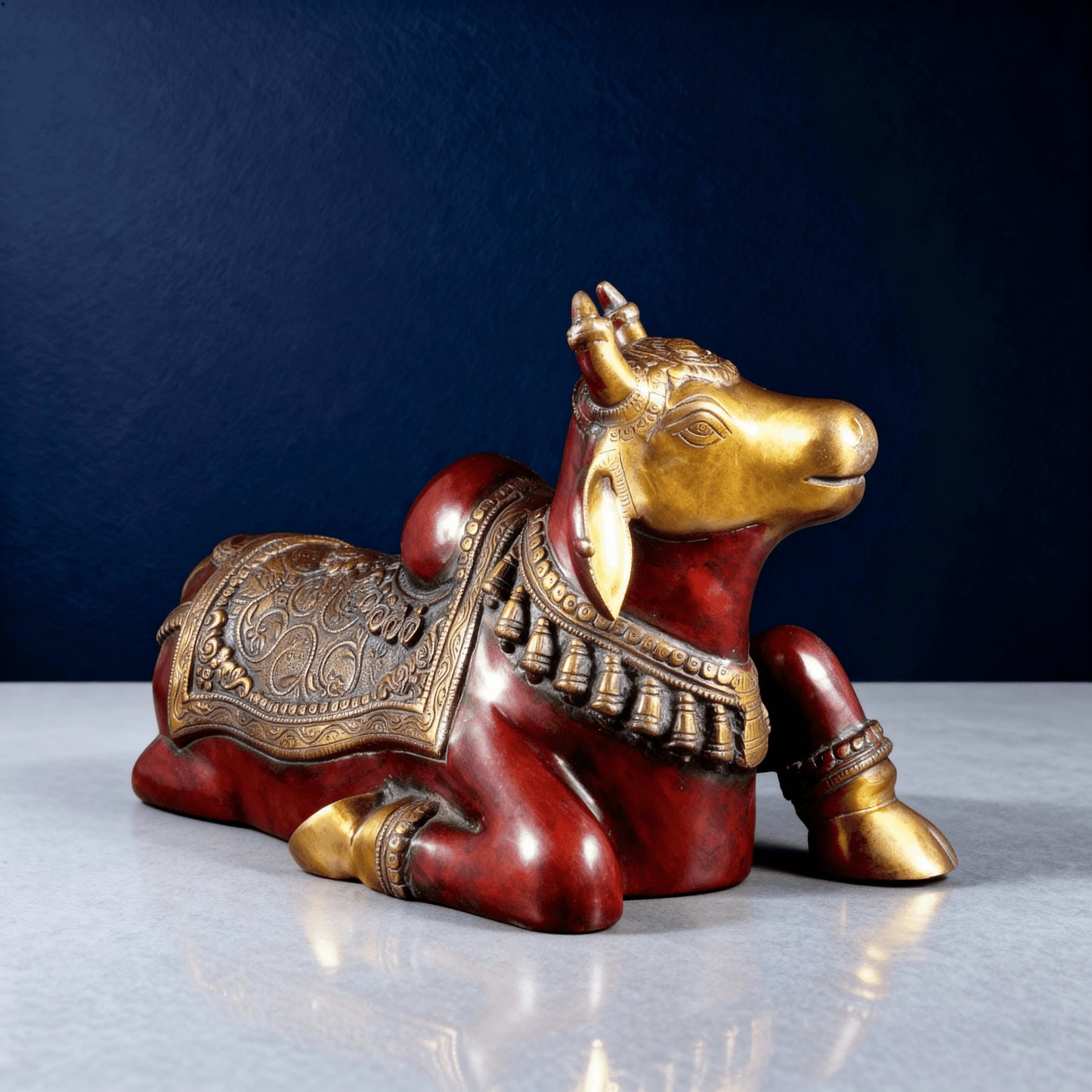 Close-up of red and gold Nandi sculpture with detailed facial and neck ornaments