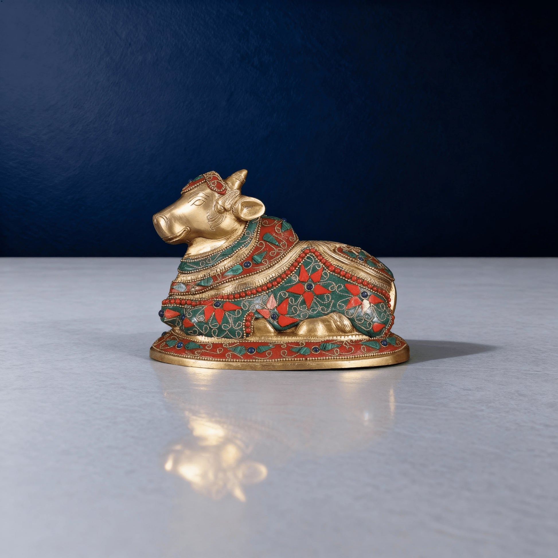 side angle shot of meenakari brass nandi idol with detailed floral patterns