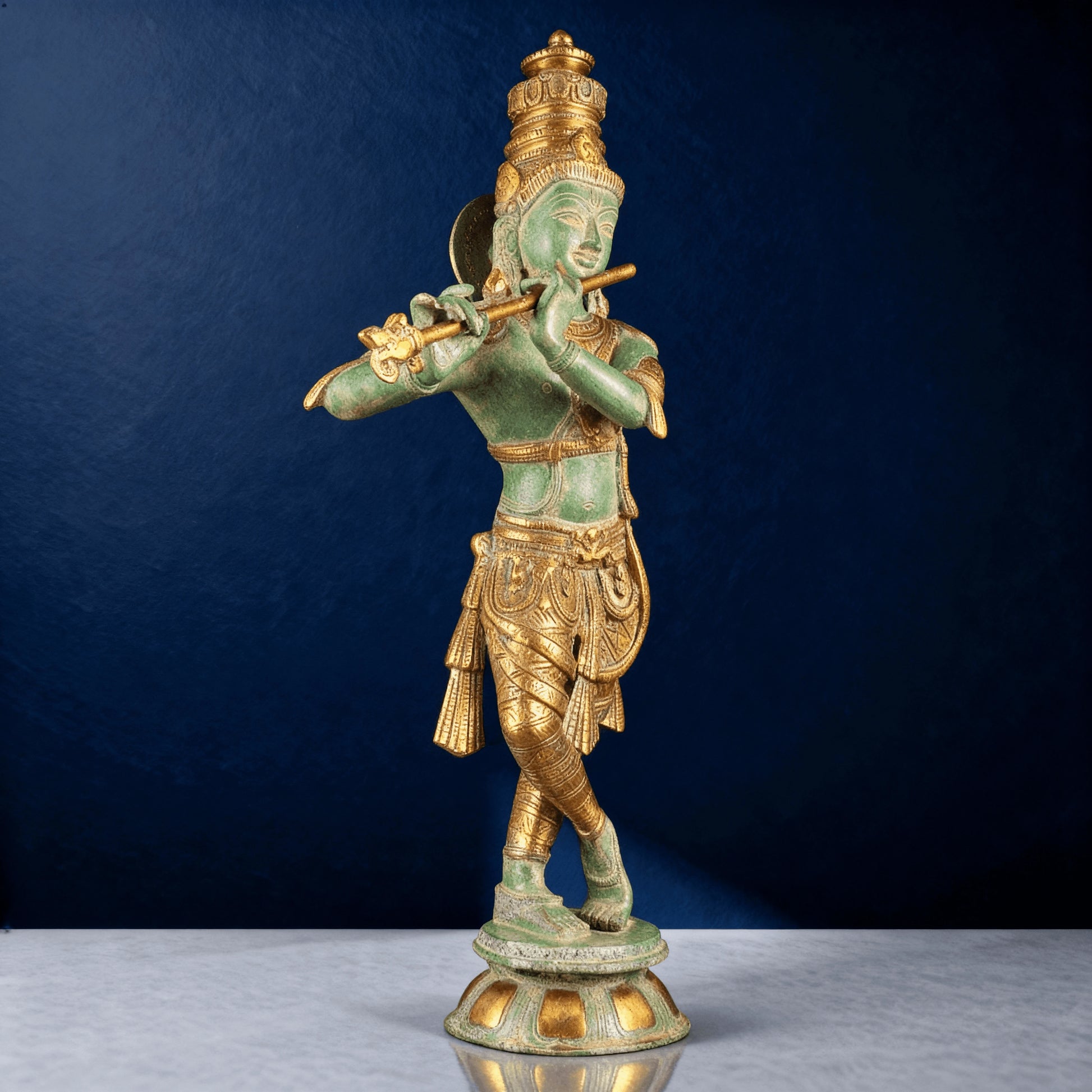 Front view of green antique-finish brass Krishna playing flute